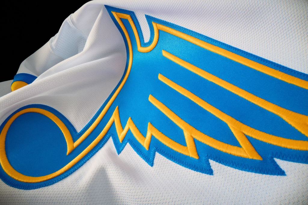 Close-up of the updated 2025 St. Louis Blues Blue Note logo on a white jersey with blue and yellow stitching