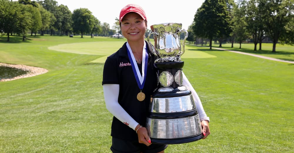 Maelynn Kim holds the Women's Western Amateur championship trophy on the golf course at Red Run Golf Club.