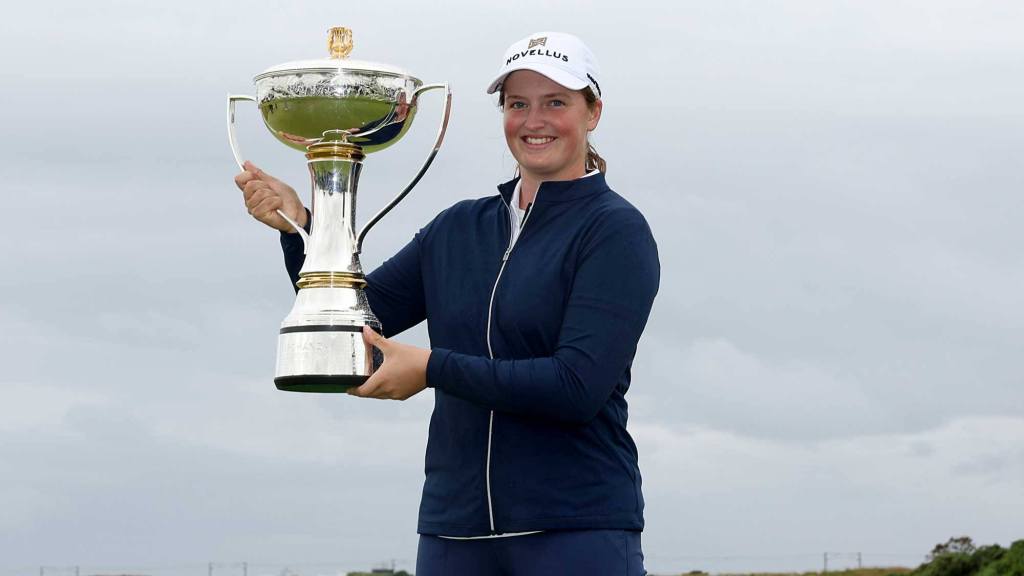 Lottie Woad holding the Scottish Open trophy after winning her professional debut in 2025