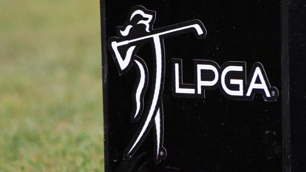 Close-up of the LPGA Tour logo in white on a black tee box marker, showing a silhouette of a female golfer mid-swing with the letters "LPGA" beside it.